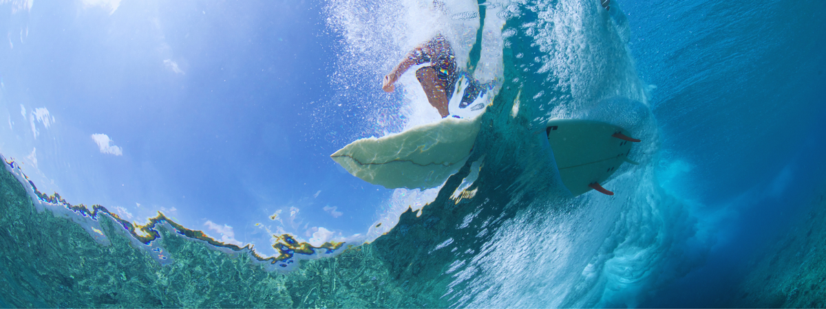 Surfer riding a wave, seen from underwater